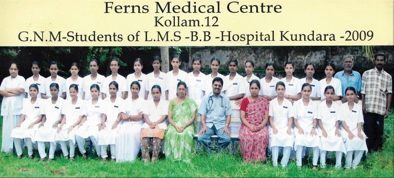 Group photo of nursing students in white uniforms with Dr. Nicholas Christy seated in the centre