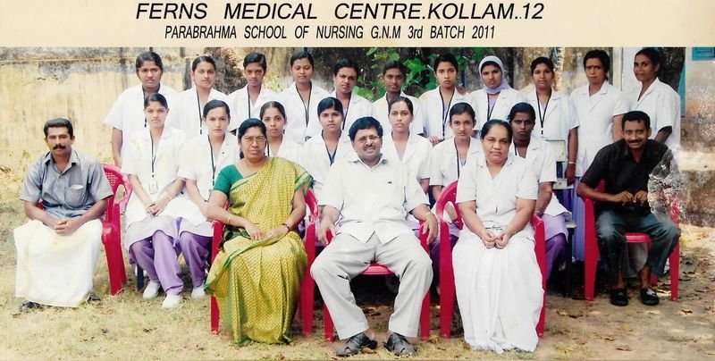 Group photo of nursing students in white coats with Dr. Nicholas Christy seated in the centre
