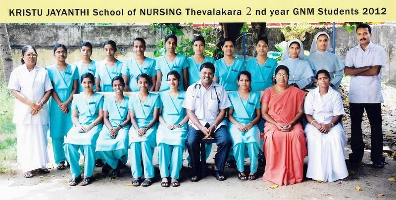 Group photo of nursing students in light blue uniforms with Dr. Nicholas Christy and faculty