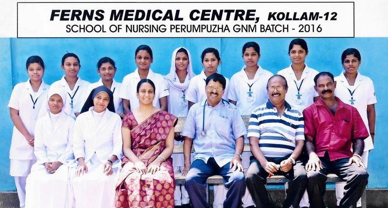 Group photo of nursing students in white uniforms with Dr. Nicholas Christy and faculty