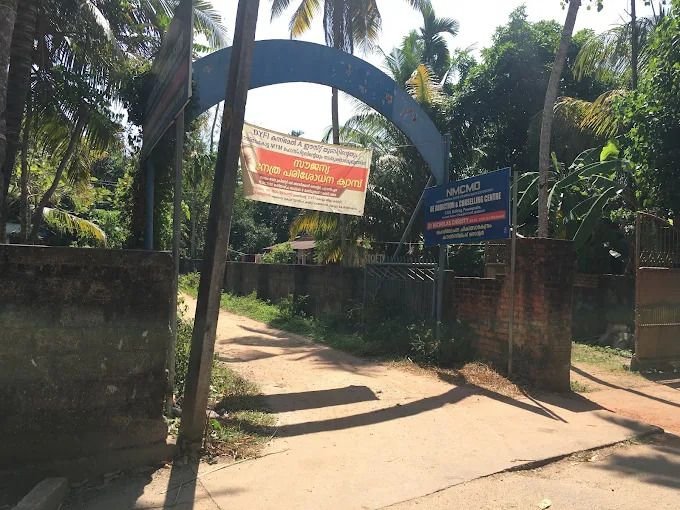 The arched blue entrance gate of the C.S.S. campus with the NMCMD board beside it
